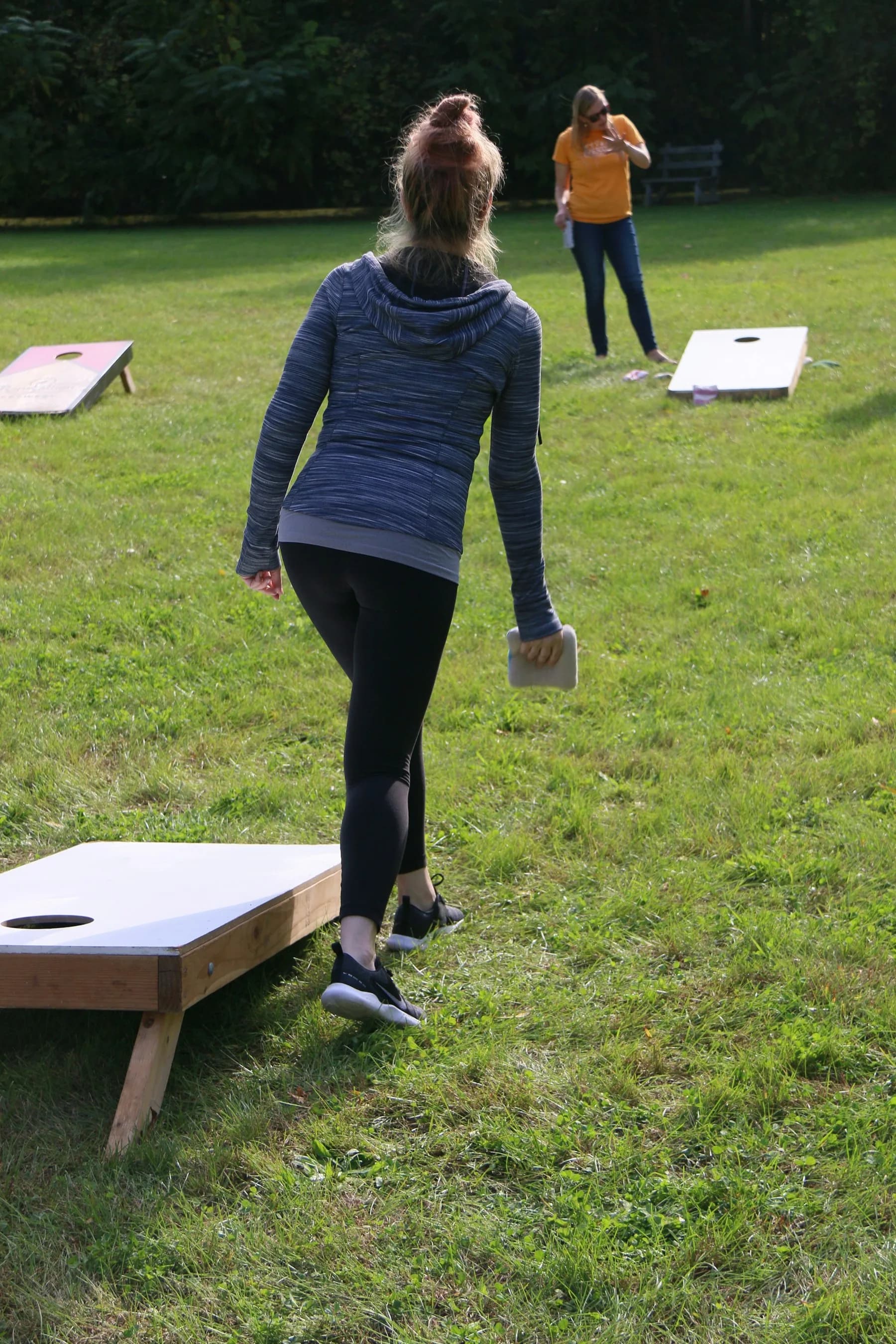 Players competing with cornhole boards
